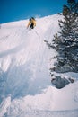 Young man skiing down a snowy mountain slope