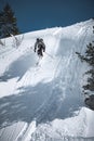 Young man skiing down a snowy mountain slope