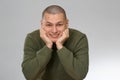 A young man is skinhead in a green military style sweater. studio. Royalty Free Stock Photo
