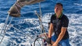 A young man the skipper controls the movement of sailing yachts during the boat race Royalty Free Stock Photo