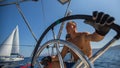 Young man skipper steering wheel during sea yacht race. Royalty Free Stock Photo