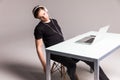 Young man sleep while wearing headphones and work on laptop on his office table on white background. work Royalty Free Stock Photo