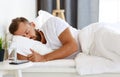 Young man sleeping in bed in bedroom in morning Royalty Free Stock Photo