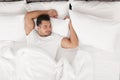 Young man sleeping in bed with soft pillows