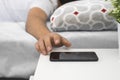 Young man sleeping in his bed with his cell phone on the nightstand,