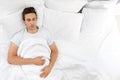 Young man sleeping on soft pillows in bed Royalty Free Stock Photo