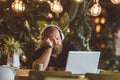 A young man sleeps fell asleep at the table with headphones in front of the computer in the restaurant Royalty Free Stock Photo