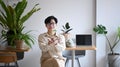 Young man small business entrepreneur holding potted plant and smiling to camera. Royalty Free Stock Photo