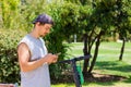 Young man with smart phone by scooter at park Royalty Free Stock Photo