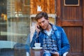 Young man with smartphone in an cafe outdoor Royalty Free Stock Photo