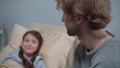 Young man smile and talk to girl who lie on the bed in the hospital