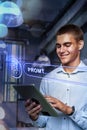 Young man using tablet to interact with AI technology in modern office setting during daytime Royalty Free Stock Photo