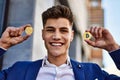 Young man smiling confident holding bitcoin and ethereum at street