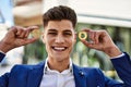 Young man smiling confident holding bitcoin and ethereum at street