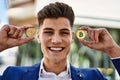 Young man smiling confident holding bitcoin and ethereum at street