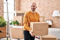 Young man smiling confident holding fragile cardboard box at new home Royalty Free Stock Photo