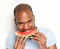 Young man smiling and eating delicious watermelon