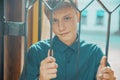 Young man smiling holding a metal grate with his hands Royalty Free Stock Photo