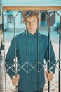 Young man smiling holding a metal grate with his hands Royalty Free Stock Photo