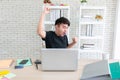 Young man smiling of a laptop computer while relaxing working on a wooden table at home. Happy Social distancing