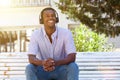 Young man smiling outside with headphones Royalty Free Stock Photo