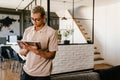 Young man smiling and using tablet computer while working in office Royalty Free Stock Photo