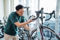 young man smiling while washing a racing bike with foaming soap