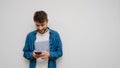 Young man smiling and watching in his phone. Hipster using his mobile device Royalty Free Stock Photo