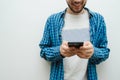 Young man smiling and watching in his phone. Hipster using his mobile device Royalty Free Stock Photo