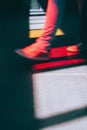 Young man in sneaker walking on the street. Bright light falling down through the colored glass windows on the floor Royalty Free Stock Photo