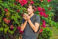 Young man sneezes because of an allergy to pollen Royalty Free Stock Photo