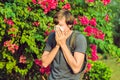 Young man sneezes because of an allergy to pollen Royalty Free Stock Photo