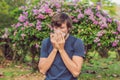 Young man sneezes because of an allergy to pollen Royalty Free Stock Photo