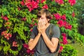 Young man sneezes because of an allergy to pollen Royalty Free Stock Photo