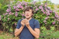 Young man sneezes because of an allergy to pollen Royalty Free Stock Photo