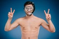 young man in snorkel and diving mask showing victory sign and looking at camera Royalty Free Stock Photo