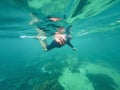 Young man snorkeling scuba diving with life jacket at the Great Barrier Reef in the tropical