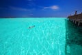 Young man snorkeling in tropical lagoon with over water bungalows Royalty Free Stock Photo