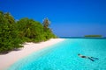 Young man snorkling in tropical island with sandy beach