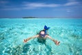 Young man snorkling in tropical lagoon with over water bungalows