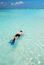 Young man snorkling in tropical lagoon with over water bungalows Royalty Free Stock Photo