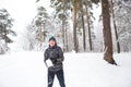 A young man with a snowball in his hand is having fun, swinging for a throw. Winter family and friendly games and entertainment in Royalty Free Stock Photo