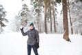 A young man with a snowball in his hand is having fun, swinging for a throw. Winter family and friendly games and entertainment in Royalty Free Stock Photo