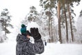 A young man with a snowball in his hand is having fun, swinging for a throw. Winter family and friendly games and entertainment in Royalty Free Stock Photo