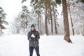 A young man with a snowball in his hand is having fun, swinging for a throw. Winter family and friendly games and entertainment in Royalty Free Stock Photo