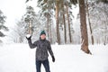 A young man with a snowball in his hand is having fun, swinging for a throw. Winter family and friendly games and entertainment in Royalty Free Stock Photo