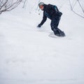 Young man snowboarding down a slope Royalty Free Stock Photo