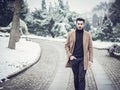 Young man in snowy city park