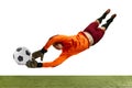 Young man, soccer football goalkeeper catches ball in jump isolated over white background. Concept of sport, action Royalty Free Stock Photo