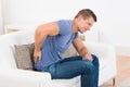 Man On Sofa Suffering From Backpain Royalty Free Stock Photo